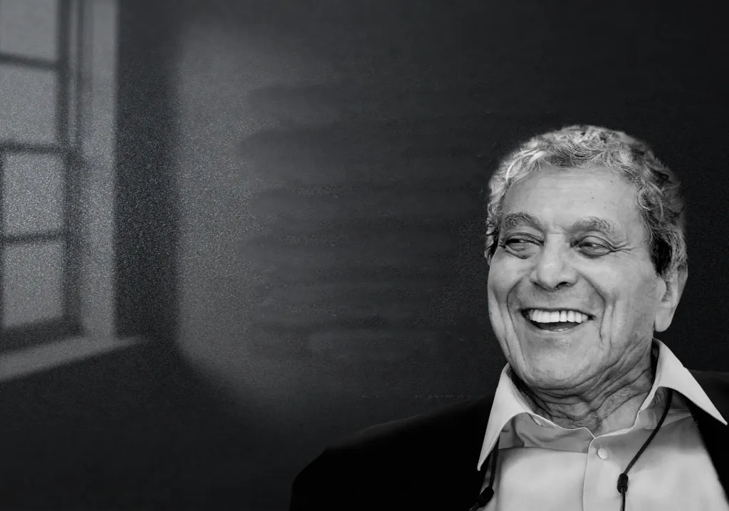 Black and white portrait of Dr. David Kantor smiling, seated in front of a softly lit window with a blurred background.